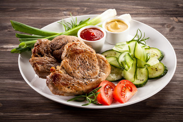 Barbecued steak, boiled potatoes and vegetable salad
