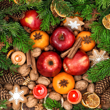 Christmas decoration with candles. Fruits, nuts, spices and cook