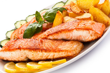 Grilled salmon and vegetables on white background