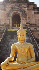 Fototapeta premium golden buddha in front of ruins temple, Thailand