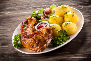 Barbecued chicken leg with boiled potatoes and vegetables