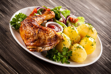 Barbecued chicken leg with boiled potatoes and vegetables