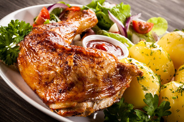 Barbecued chicken leg with boiled potatoes and vegetables