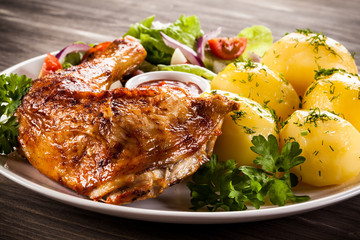 Barbecued chicken leg with boiled potatoes and vegetables
