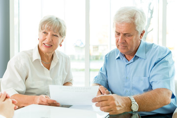 Senior couple read the form for life insurance