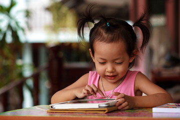 Happy child playing tablet.