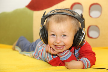 funny kid listening to music in headphones - 74237504