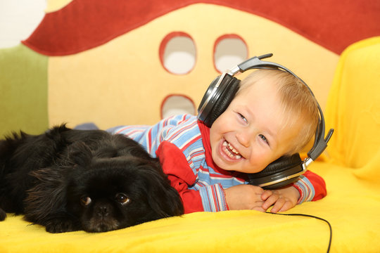 Funny Kid With A Dog Listening To Music In Headphones