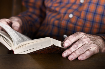 Old man hands holding a book