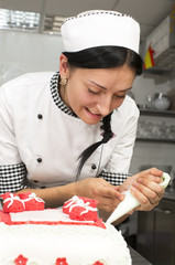 pastry chef decorates a cake in a candy store