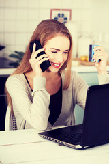 Beautiful caucasian woman talking through phone and working with