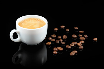 Coffee beans and fresh coffee in white cup on black background