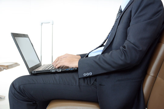 Businessman using laptop computer waiting for the flight