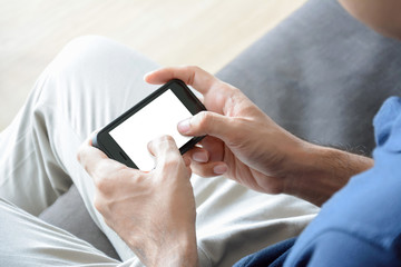 A man using smartphone while sitting on the couch