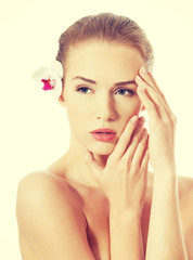 Fototapeta premium Portrait of beautiful caucasian woman with orchid flower.