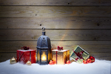 Christmas gifts with lantern in snow