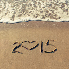 2015 year written on sandy beach. Toned image
