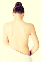 Naklejka premium Attractive naked woman's back covered with towel.