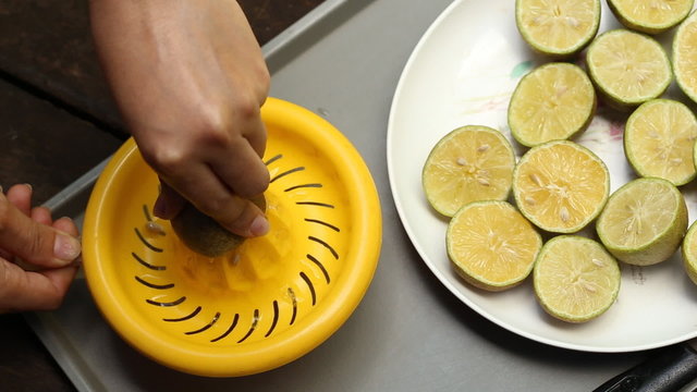 Preparing fresh lemon juice squeezed with hand juicer