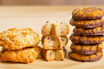Different cookies in piles on wooden table