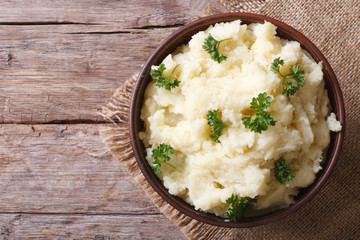 Hot mashed potatoes with parsley in a bowl close-up. top view