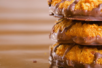 Pile of brown cookies with chocolate strips on yellow glossy