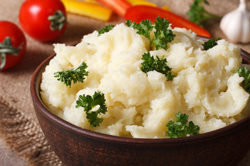 Delicious mashed potatoes with parsley closeup on the table