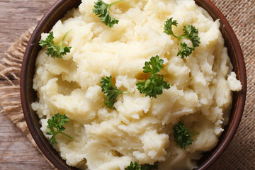 mashed potatoes with parsley in a bowl macro top view