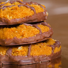 Pile of brown cookies with chocolate strips on yellow glossy
