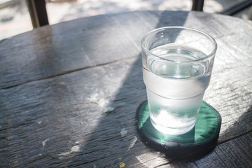Glass of cold drinking water on wooden table