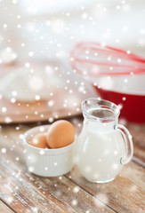 Obraz na płótnie Canvas close up of milk jug, eggs, whisk and flour