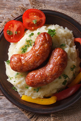 sausages and mashed potatoes on a plate top view vertical