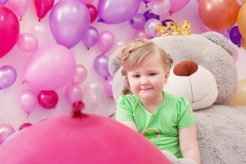 Fototapeta na wymiar Neat little girl posing in studio with balloons