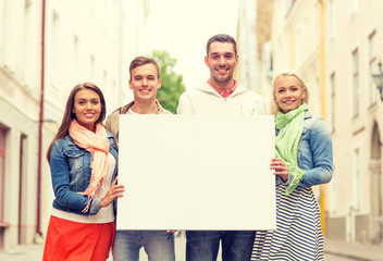 group of smiling friends with blank white board