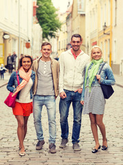 Fototapeta premium group of smiling friends walking in the city