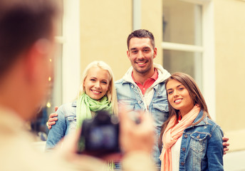 group of smiling friends taking photo outdoors