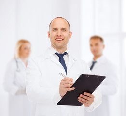 Fototapeta na wymiar smiling male doctor with clipboard