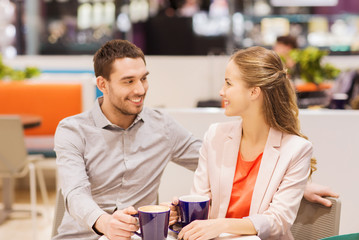 happy couple with shopping bags drinking coffee