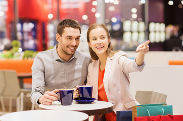 happy couple with shopping bags drinking coffee