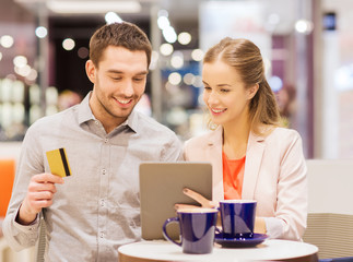 couple with tablet pc and credit card in mall