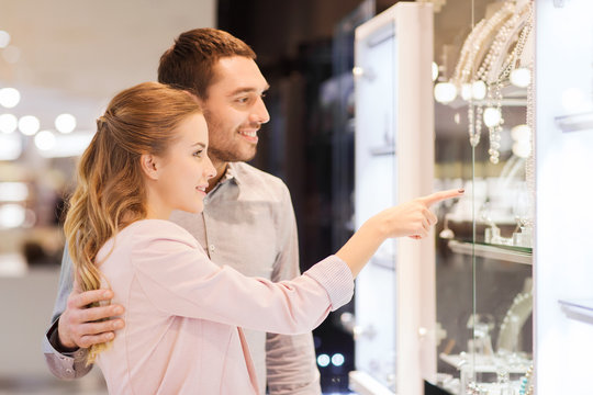couple looking to shopping window at jewelry store