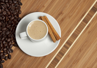 Cappuccino and spilled out coffee beans.