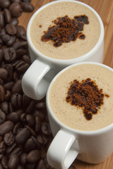 Cappuccino and spilled out coffee beans.