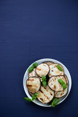 Grilled aubergine with green basil, view from above, copyspace
