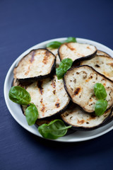 Close-up of grilled aubergine slices on a plate, vertical shot