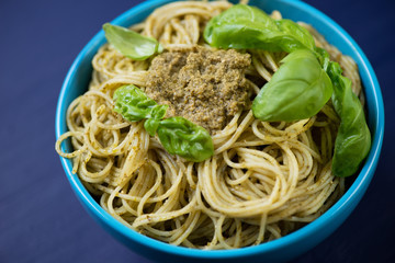 Close-up of a glass bowl with spaghetti served with basil pesto