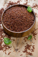 Red kernel rice in a wooden bowl, close-up, studio shot
