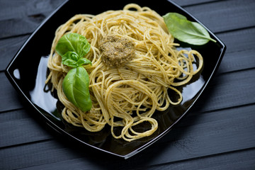 Spaghetti with pesto sauce and fresh green basil leaves