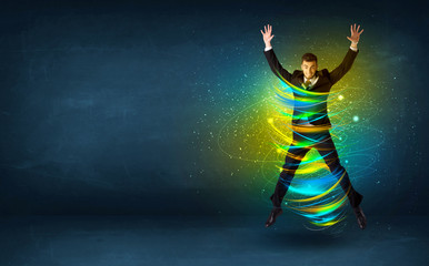 Excited business man jumping with energy colourful lines - obrazy, fototapety, plakaty