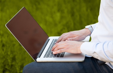 Businessman pressing modern laptop computer on colorful backgrou